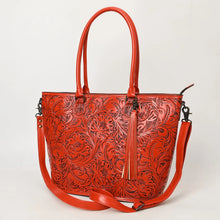 Load image into Gallery viewer, Maple Creek hand tooled leather concealed carry tote in red, angled view showing antiqued floral tooling, tassel and strap

