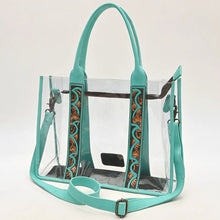Load image into Gallery viewer, Turquoise Trail hand tooled leather clear tote with adjustable turquoise crossbody strap, angled view
