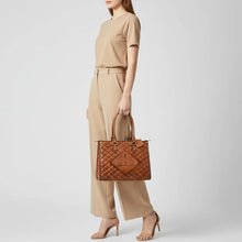 Load image into Gallery viewer, Model carrying the Hattie quilted leather boot stitch tote by its rolled handles
