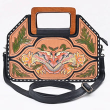 Load image into Gallery viewer, Moonflower hand tooled leather crossbody purse front view with hand-painted moth, floral carving, wooden handles, and black strap
