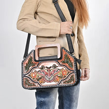 Load image into Gallery viewer, Moonflower hand tooled leather purse worn crossbody on the adjustable black leather strap over a tan blazer
