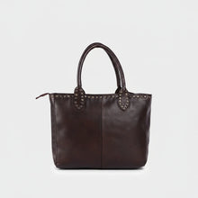 Load image into Gallery viewer, Starla studded leather tote in espresso brown, front view with rolled handles, center seam and brass stud trim along the zip top
