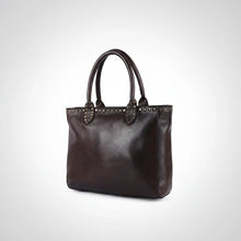 Load image into Gallery viewer, Starla studded leather tote in espresso brown, angled side view showing depth, rolled handles and brass stud trim
