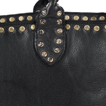Load image into Gallery viewer, Close-up of Starla tote in black showing star-stamped antique brass studs on the topline and handle tab over full-grain leather
