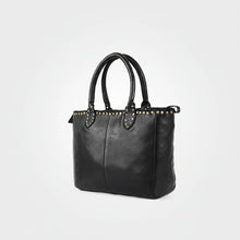 Load image into Gallery viewer, Starla studded leather tote in black, angled side view showing depth, rolled handles and brass stud trim
