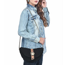 Load image into Gallery viewer, Woman wearing the Sundown black suede cactus concho crossbody on a chain strap with a denim shirt
