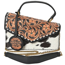 Load image into Gallery viewer, Domino black-and-white hair-on cowhide messenger with hand-tooled floral flap, top handle and chain strap, front view
