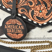 Load image into Gallery viewer, Close-up of Domino's hand-carved floral tooling, turquoise-colored accents and white buckstitch trim
