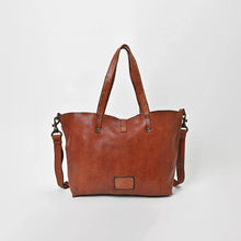 Load image into Gallery viewer, Back of the Amber riveted leather tote in cognac showing the leather logo patch, riveted handles and detachable strap
