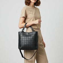 Load image into Gallery viewer, Model carrying the Winslow black Italian leather grid tote over her arm
