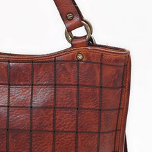 Load image into Gallery viewer, Close-up of the Winslow cognac leather scored grid, star-stamped rivet and antique brass handle ring
