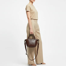 Load image into Gallery viewer, Model carrying the Riva dark brown Italian leather riveted mini tote with crossbody strap
