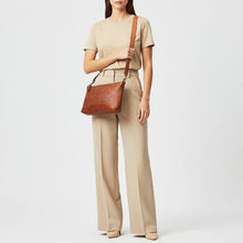 Load image into Gallery viewer, Woman wearing the Tawny tan slim leather crossbody over one shoulder
