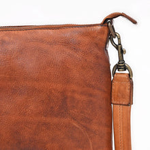 Load image into Gallery viewer, Close-up of the natural grain, zip top, and antique brass swivel clip on the Tawny tan leather crossbody
