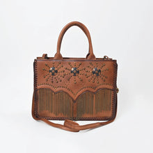 Load image into Gallery viewer, Solstice cognac leather tote with brass sunburst studs, three conchos and ball-chain fringe, front view with shoulder strap
