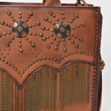 Load image into Gallery viewer, Close-up of Solstice's antique brass studs, copper-and-black conchos, chain fringe and braided whipstitch edge
