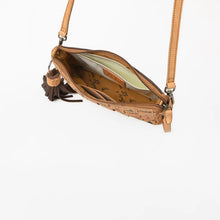 Load image into Gallery viewer, A tan leather crossbody bag with a matching shoulder strap, shown open to reveal its interior. The exterior features a textured embossed pattern, and a dark brown leather tassel hangs from the zipper.
