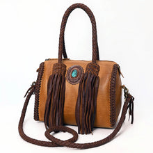 Load image into Gallery viewer, Reata leather barrel satchel in Honey Tan, angled front view showing braided top handles, fringe tassels, and turquoise concho
