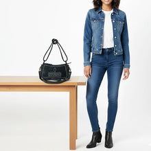 Load image into Gallery viewer, Emilie black suede boot stitch purse styled on a table beside a woman in a denim jacket, jeans and black ankle boots
