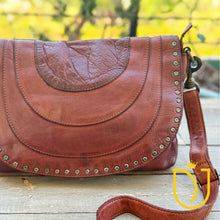 Load image into Gallery viewer, Close-up of the Venezia cognac leather flap showing stitched arc panels, crinkled leather crescent, and star-stamped studs
