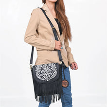 Load image into Gallery viewer, Model wearing the Raven embroidered fringe leather crossbody with a tan blazer and jeans
