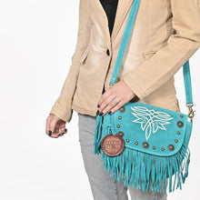 Load image into Gallery viewer, Close-up of a woman wearing the turquoise Sparrow suede fringe crossbody with chain fringe
