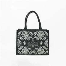 Load image into Gallery viewer, Lacey embroidered leather western tote bag, front view, black leather with white floral damask embroidery, boot-stitch centerpiece, saguaro cacti, and whipstitched edges
