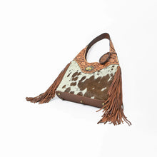 Load image into Gallery viewer, Appaloosa hobo from below, showing the leather base with brass feet and side fringe
