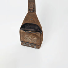 Load image into Gallery viewer, Austin western sling bag seen from above with the main compartment unzipped, showing the dark lined interior, branded label, and the curved top zipper that wraps down each side of the front panel
