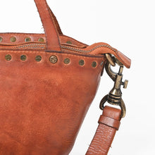Load image into Gallery viewer, Close-up of Riva cognac leather rivets, star-stamped stud, zip top and antique brass swivel hook
