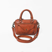 Load image into Gallery viewer, Front view of the Clementine cognac leather satchel crossbody with studded trim, snap-flap front pocket, top handles, and adjustable strap
