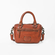 Load image into Gallery viewer, Back view of the Clementine cognac leather satchel with a studded zip pocket, embossed logo patch, rolled top handles, and swivel strap clasps
